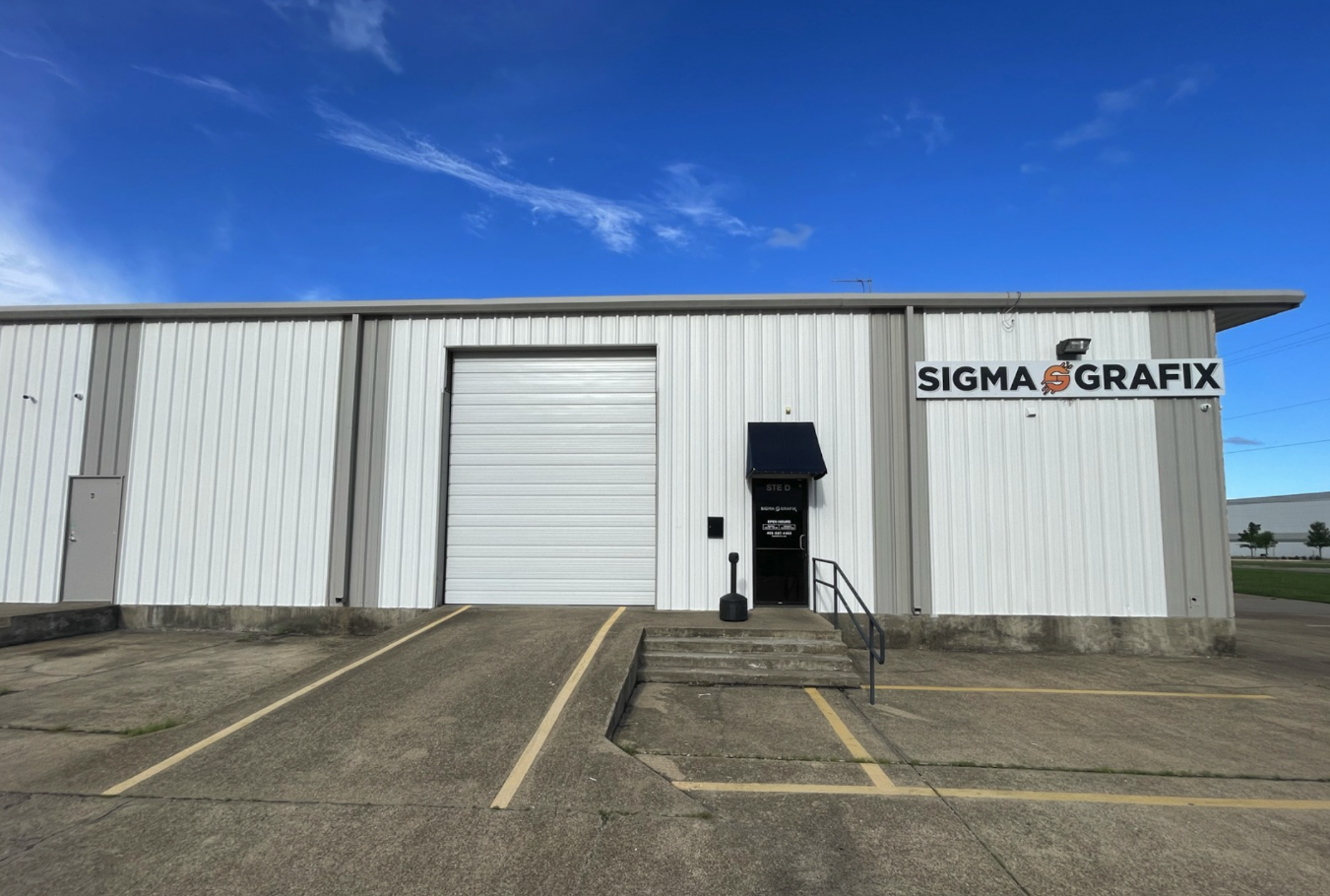 Wrapped trucks and vans parked outside the SigmaGrafix Mesquite vehicle wrap and printing shop